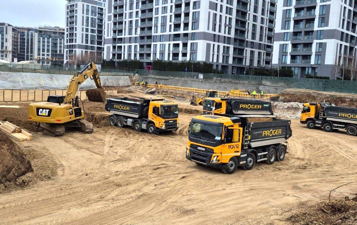 Autobasculante Proger și excavator pe un șantier de lucrări civile urbane